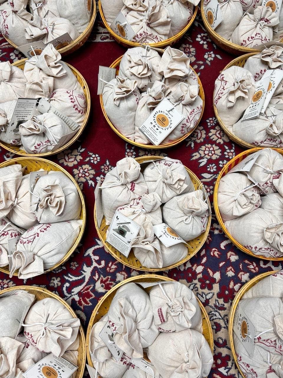 Muslin-wrapped branded pouches arranged in cane baskets, packed for a first market order