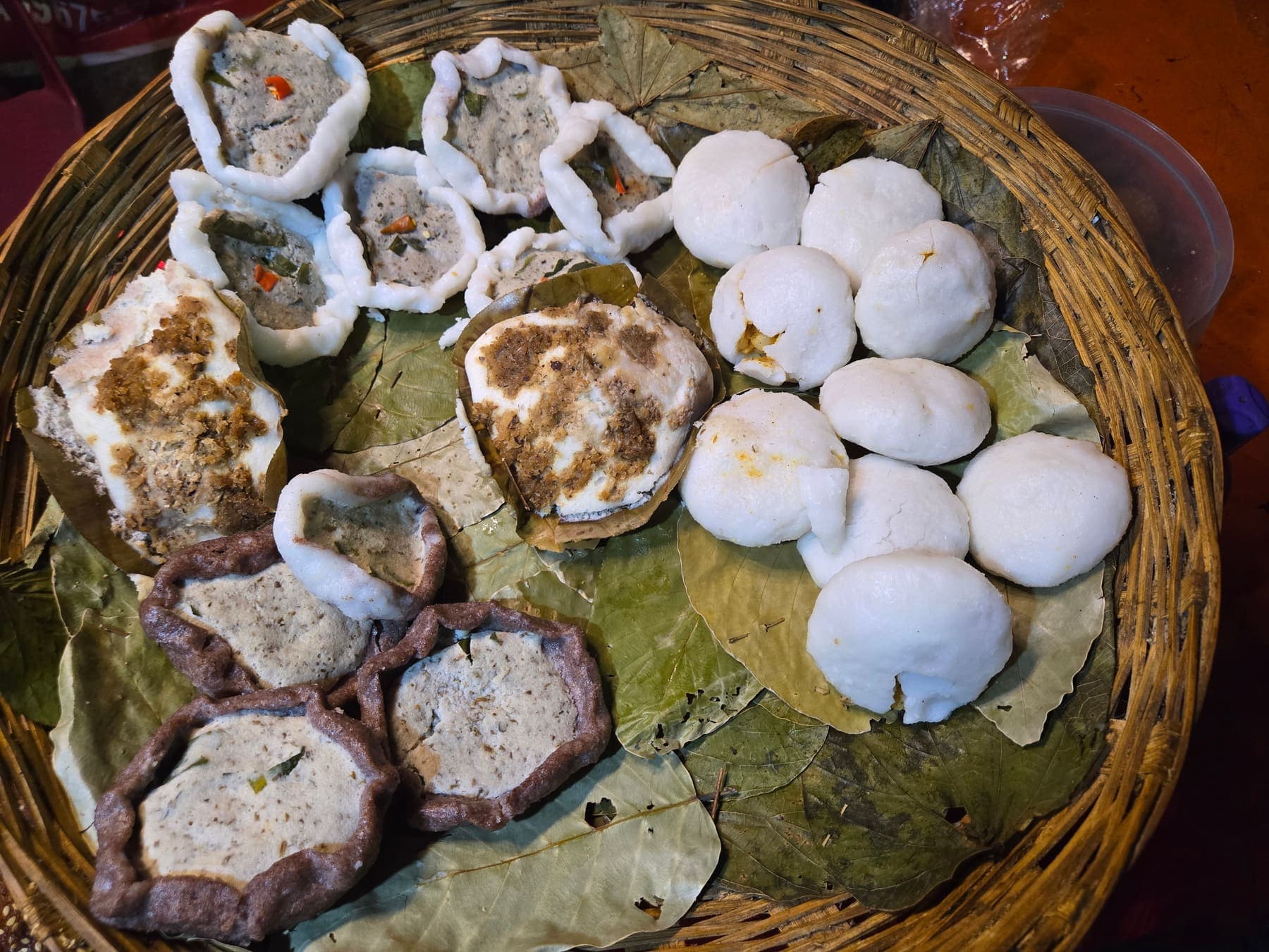 Traditional steamed rice cakes served on a leaf-lined cane basket