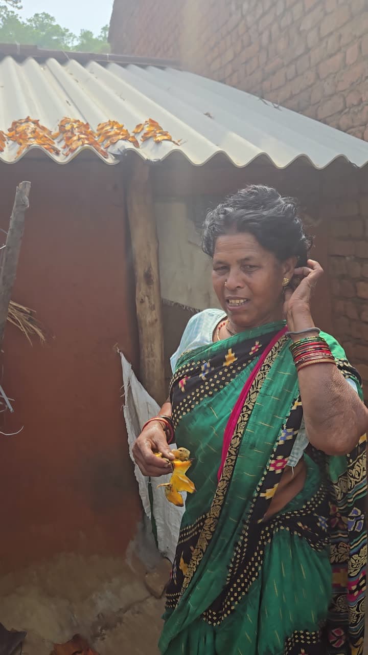 A woman producer standing outside her home in a Kandhamal village