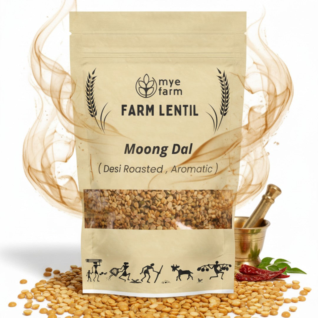 Hero image of Mye Farm Desi Roasted Moong Dal product packaging, featuring a prominent aroma graphic (steam) swirling around the pack. The image also includes scattered roasted moong dal grains, a brass mortar and pestle, and dried chili and leaf, emphasizing the aromatic and traditional quality.