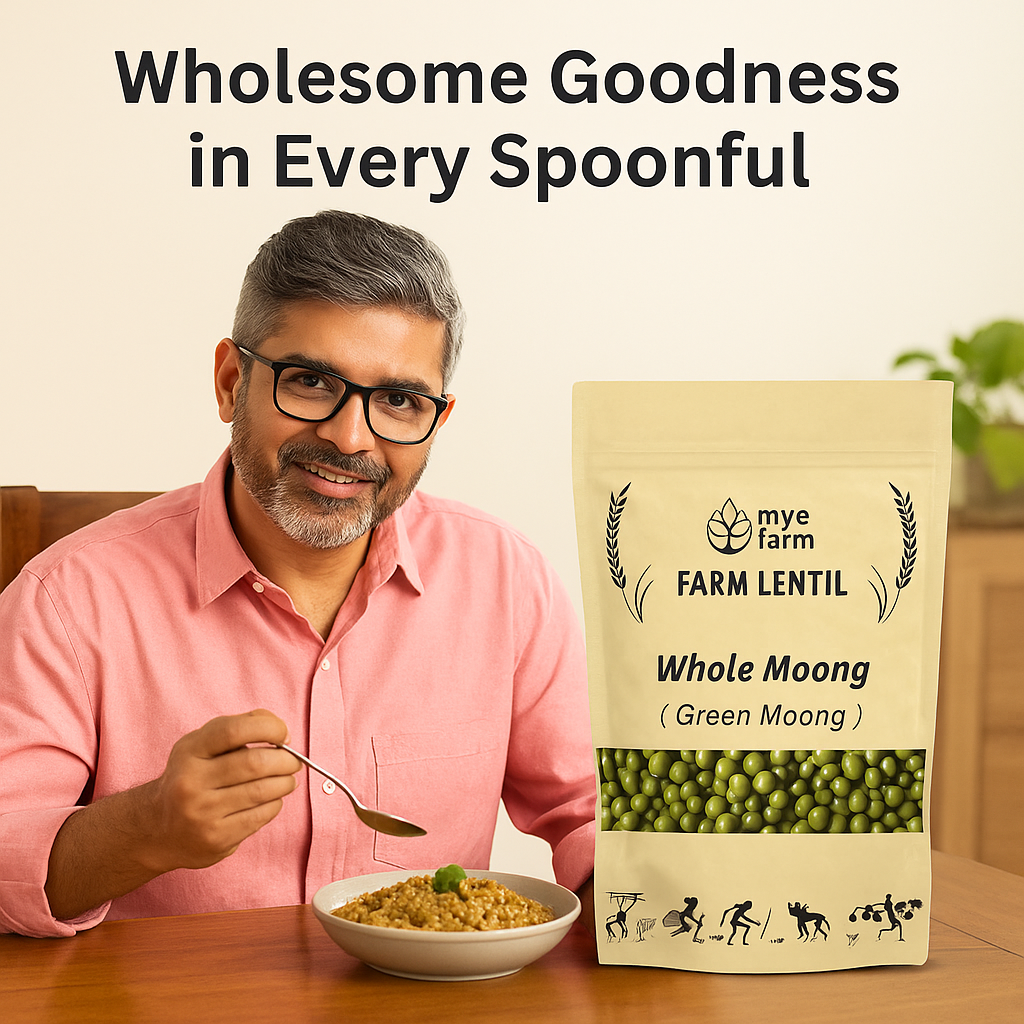 A smiling middle-aged man wearing glasses is sitting at a wooden table and enjoying a spoonful of a cooked dish, likely khichdi or dal, made with Whole Moong. The Mye Farm product packaging stands next to his bowl. Overlay text reads: Wholesome Goodness in Every Spoonful.