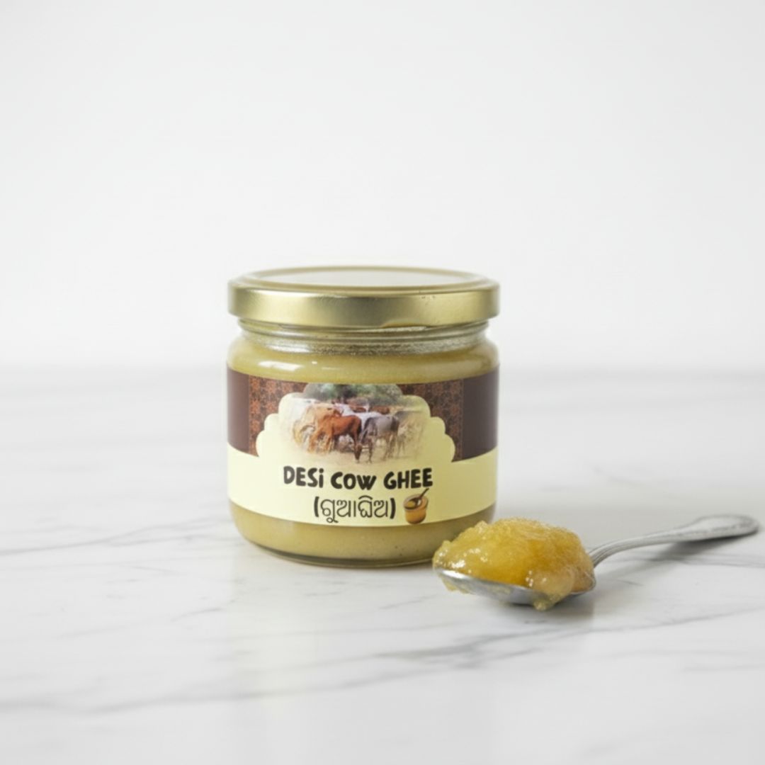Jar of Mye Farm Pure Desi Cow Ghee placed on white marble surface with a spoonful of golden ghee, showcasing its rich texture and natural shine. 100% pure, farm fresh, preservative-free desi cow ghee made in Orissa.